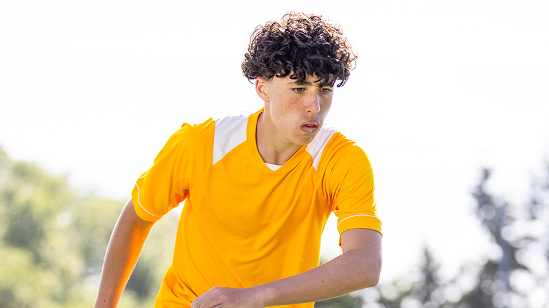 A boy kicking a soccer ball