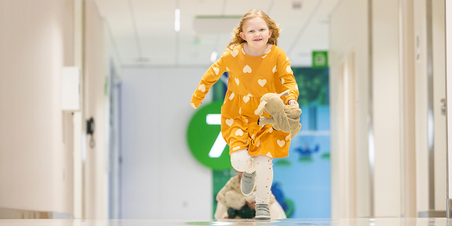 A girl runs down a hallway at Seattle Children's Hospital