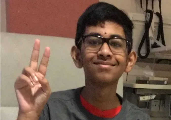 Smiling teenage patient in glasses and gray shirt with hand making peace sign
