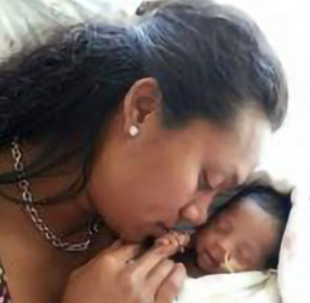 Mother cradles her sleeping baby close to her face