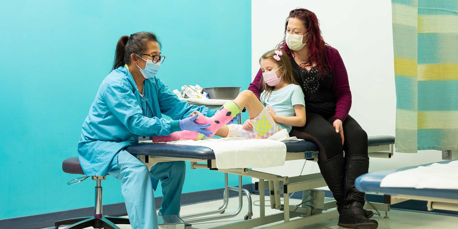 A Seattle Children's provider checking a patient while the patient's mother watches