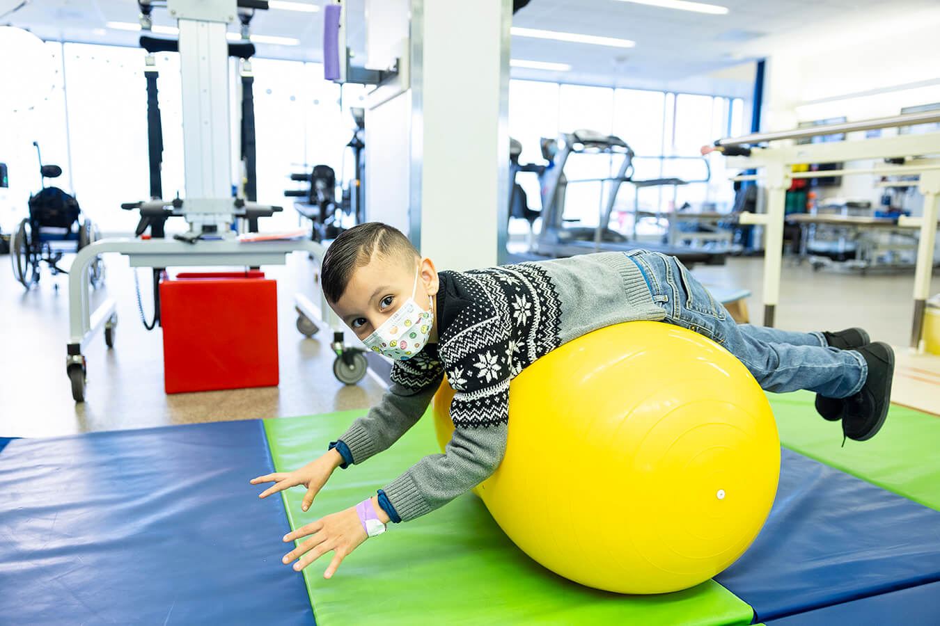 A boy on a yellow exercise ball