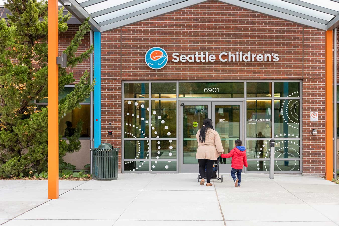 Mother with strolled and son walk towards the entrance of Seattle Children's Magnuson location