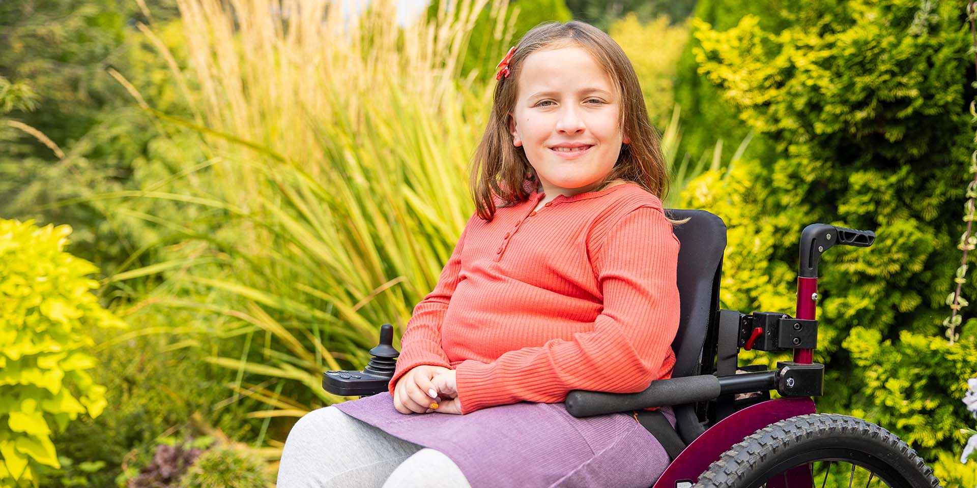A girl in a wheelchair poses for a picture