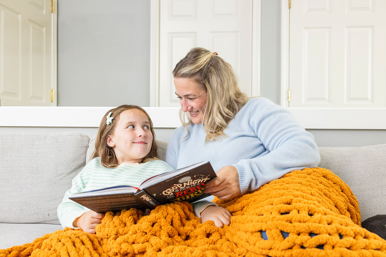 A mother and daughter read in bed