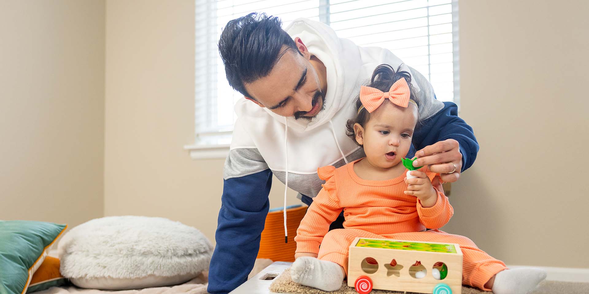 Dad with daughter playing with a toy