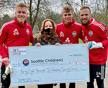 Kick Childhood Cancer Guild's Founder and Guild President, Christine O'Connell pictured with Seattle Sounders players.