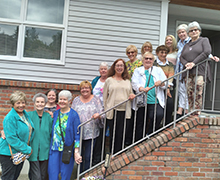 Des Moines Auxiliary Guild members standing together on a staircase