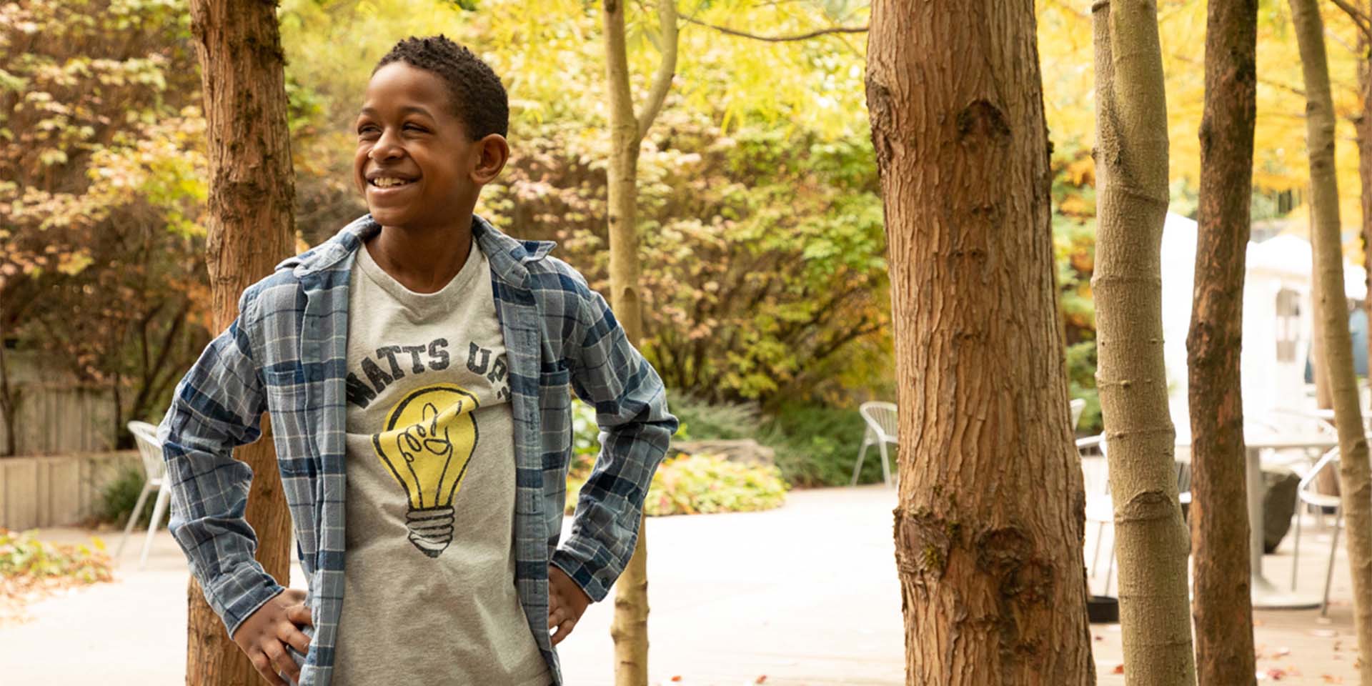 Caleb with hands on hips in front of trees