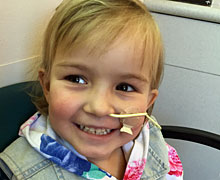 Emmy smiling with a feeding tube