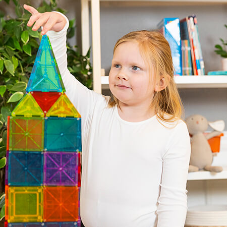 Young girl playing with magnetic tiles