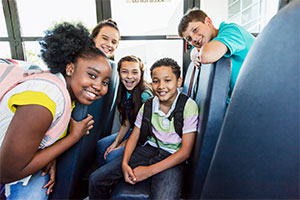 Children on a school bus smiling