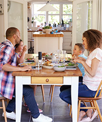 A family eats together at a dinner table.