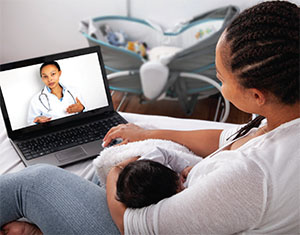 A mother participates in a virtual doctor visit while holding her baby.