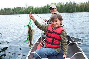 Boy wearing a life jacket while fishing