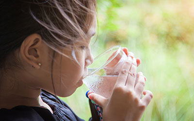Child drinking a glass of water.