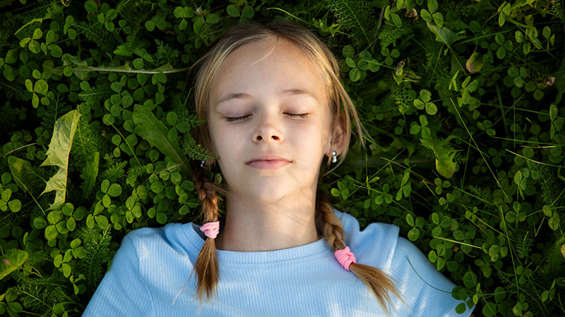 A girl lays in a clover field