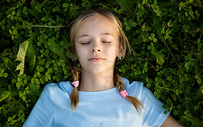 A girl lays in a clover field