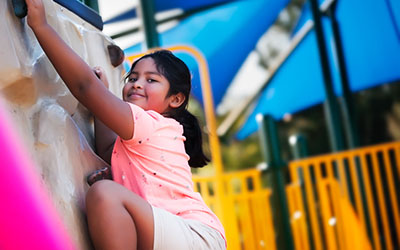 A girl on a climbing wall at a playground