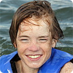 Smiling life jacket–wearing child in the water