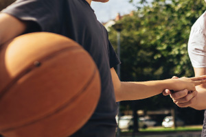 A child with a basketball has their finger examined