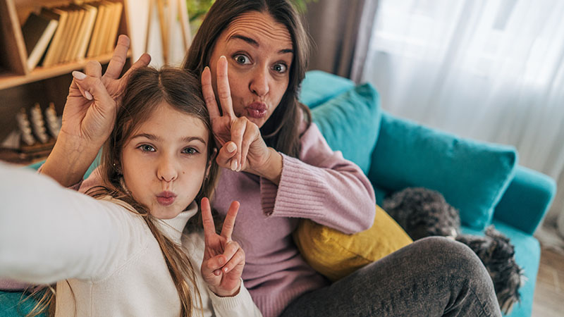 A mother and daughter make peace signs