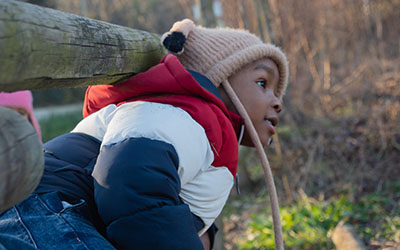 A boy in winter clothes explores the outdoors