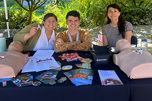 Smiling people behind a table covered in brochures