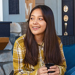A mother and daughter chat over hot drinks