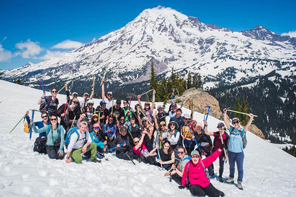 Seattle Children's residents pose in the snow in front of a mountain peak.
