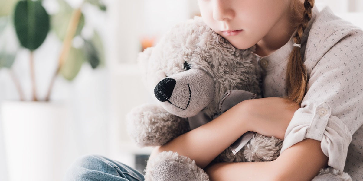 A girl holds a teddy bear