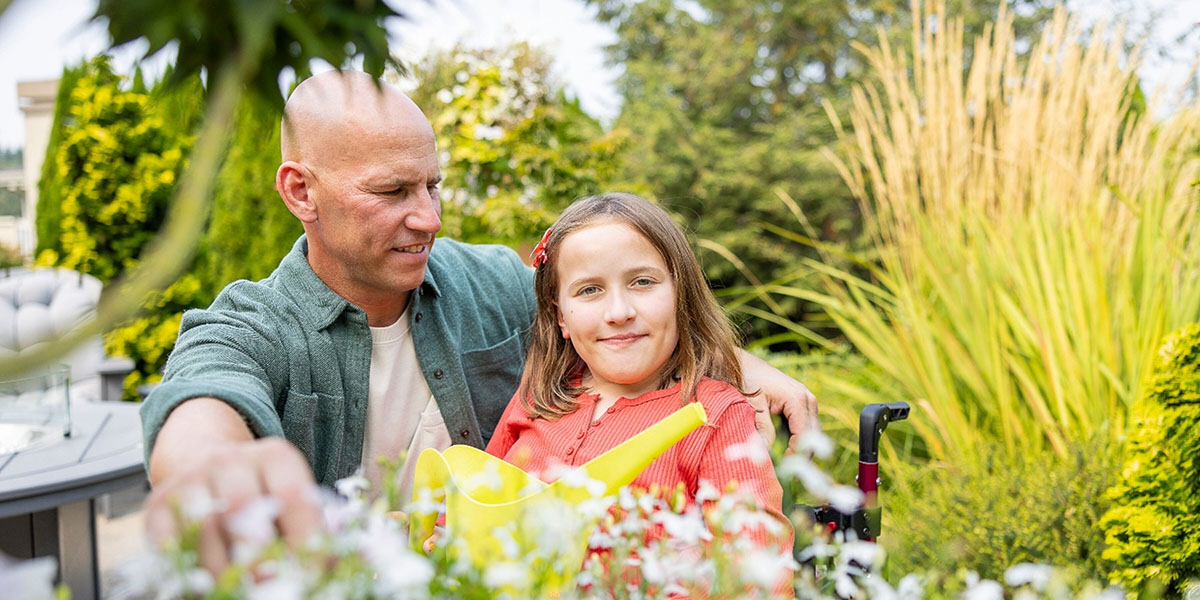 A girl and her father sit outside