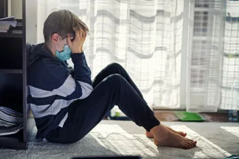 A distressed child sits on the floor