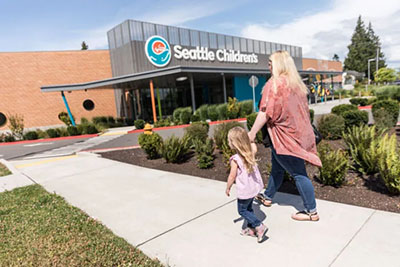 A mother and daughter walk toward Seattle Children's