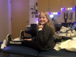 A girl sitting on a hospital chair in an exam room