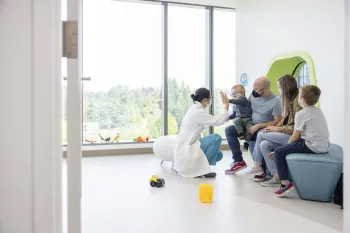 A provider sits with a family