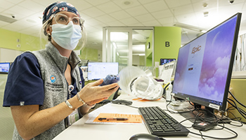 Nurse at care station in emergency department with Epic on computer screen