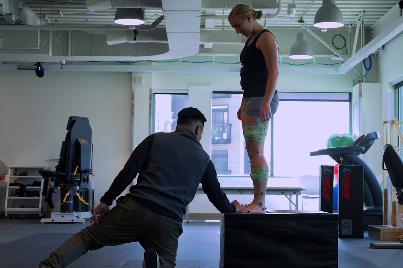 Motion analysis expert places motion capture markers on athlete