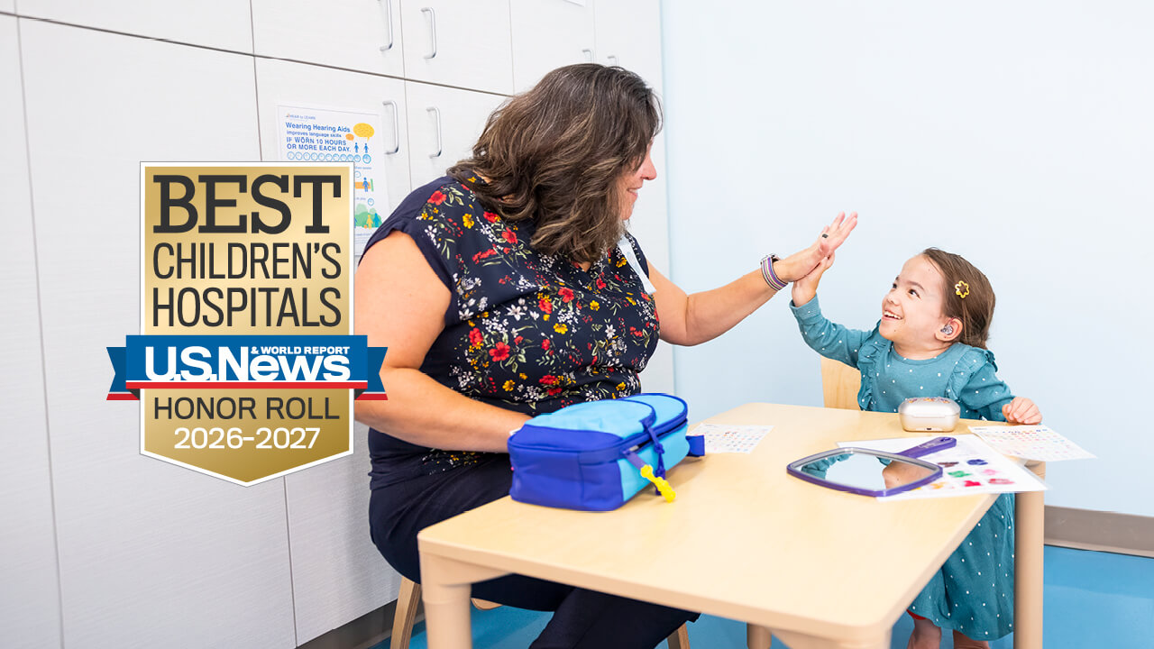 A provider high-fiving a child, with the U.S. News and World Report Best Children's Hospitals Honor Roll 2026-2027 badge