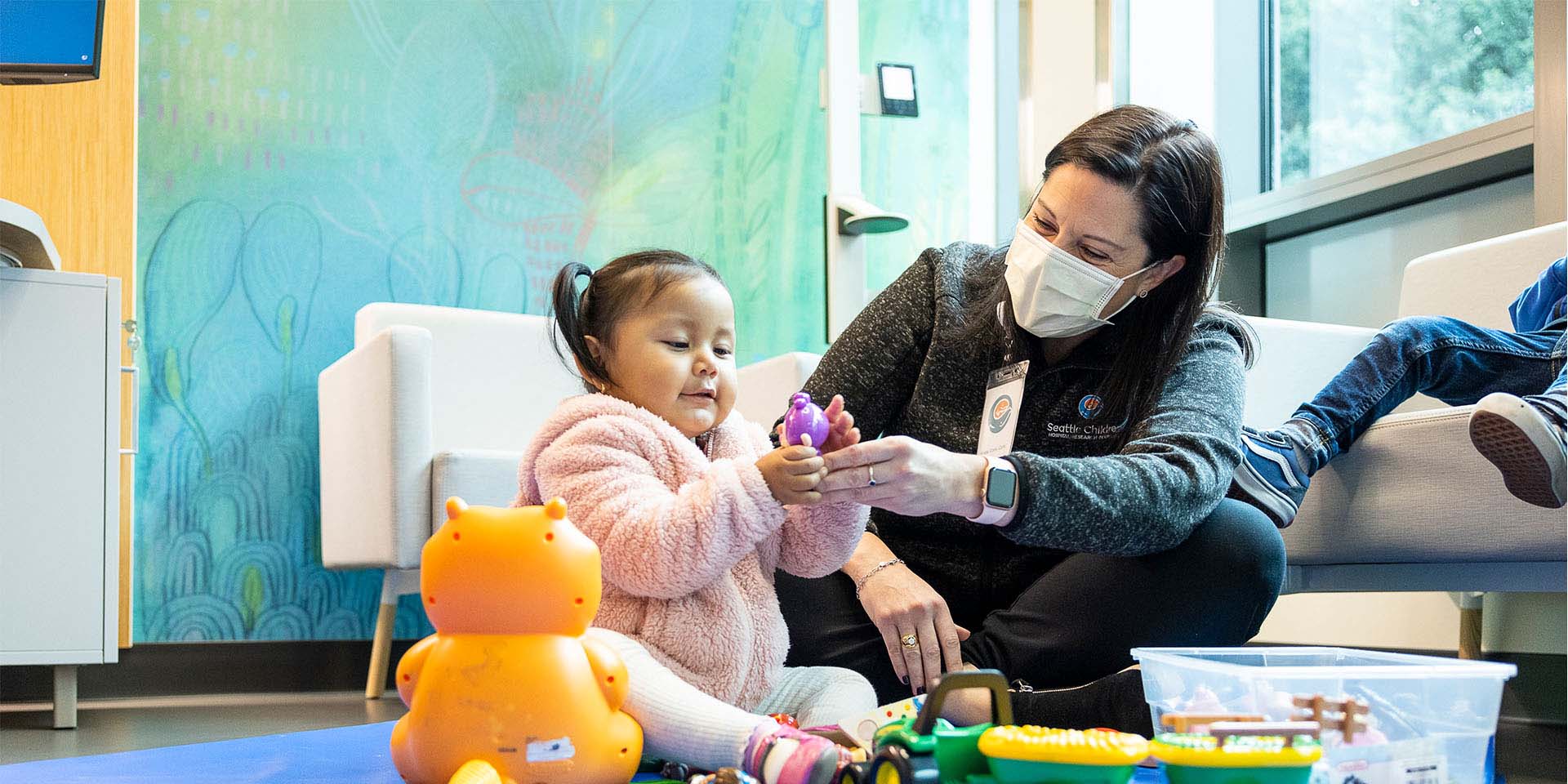 A young girl plays with a Seattle Children's provider