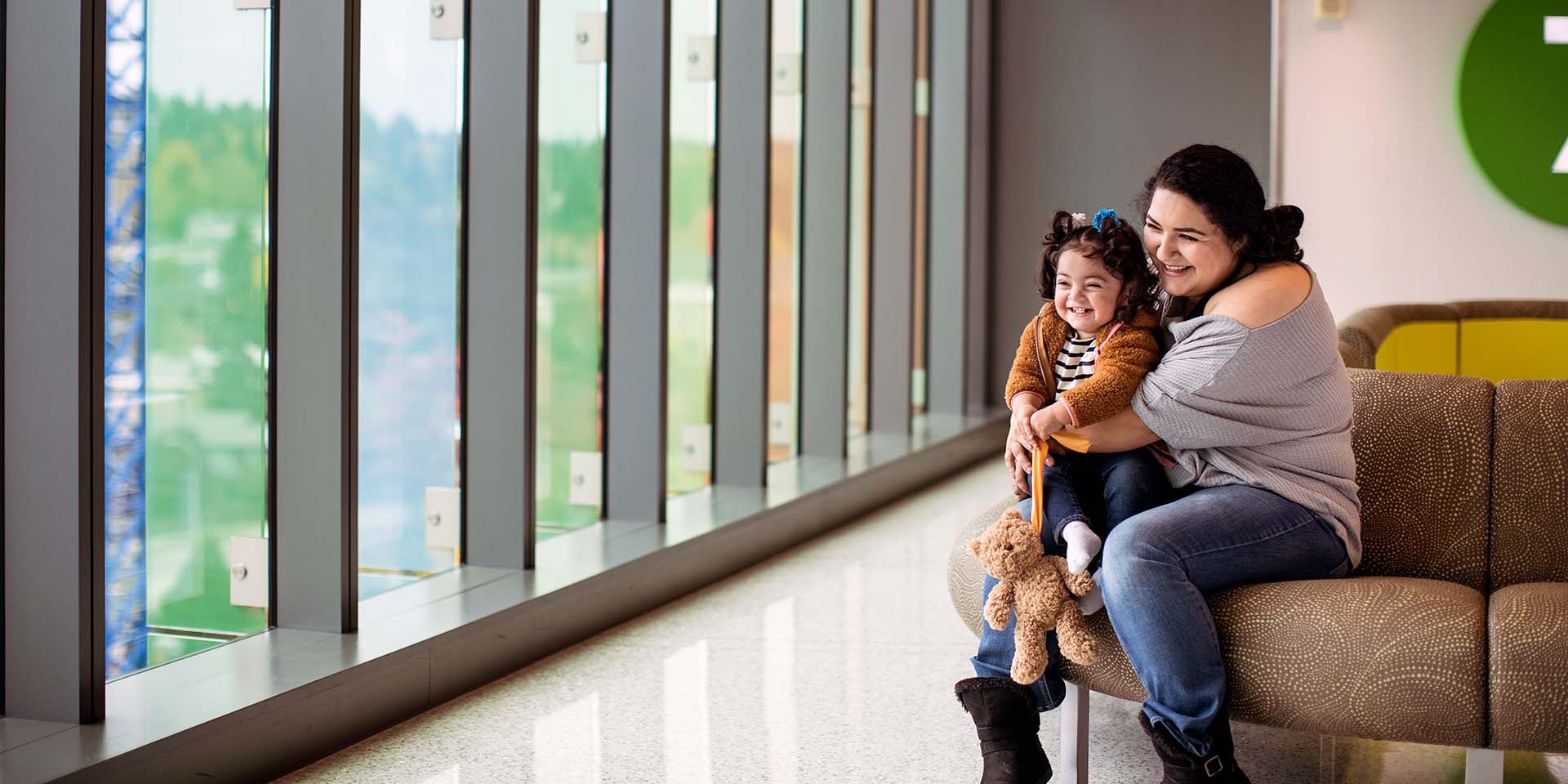 A girl and her mother look out the window at Seattle Children's hospital