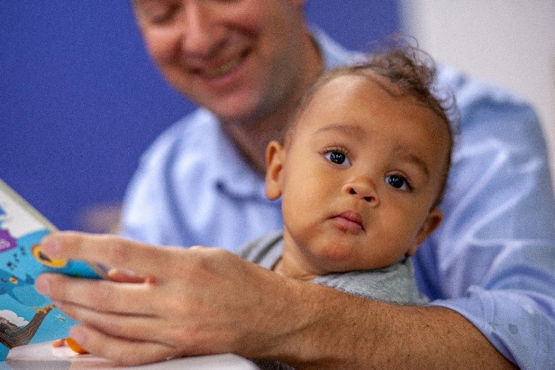 A father reads to his child.