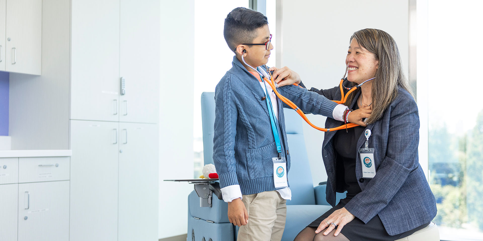 A doctor and a patient check each other with stethoscopes