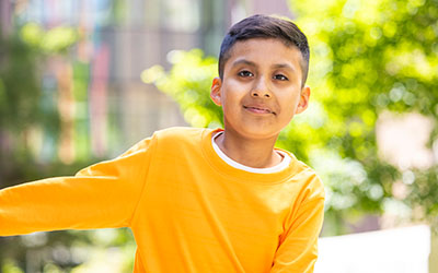A boy poses for the camera outside