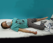 A boy laying on a bed with medical equipment attached