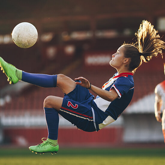 Woman kicking soccer ball