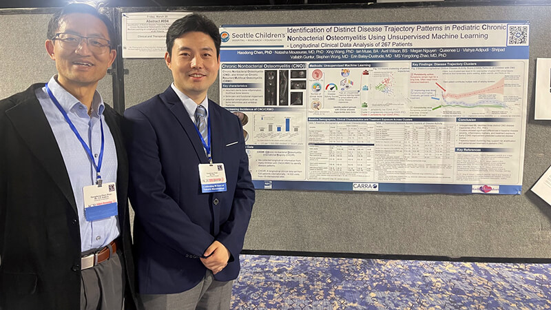 Two male researchers standing in front of a conference poster