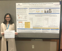 Rui Li standing by her postsurgical pain study board