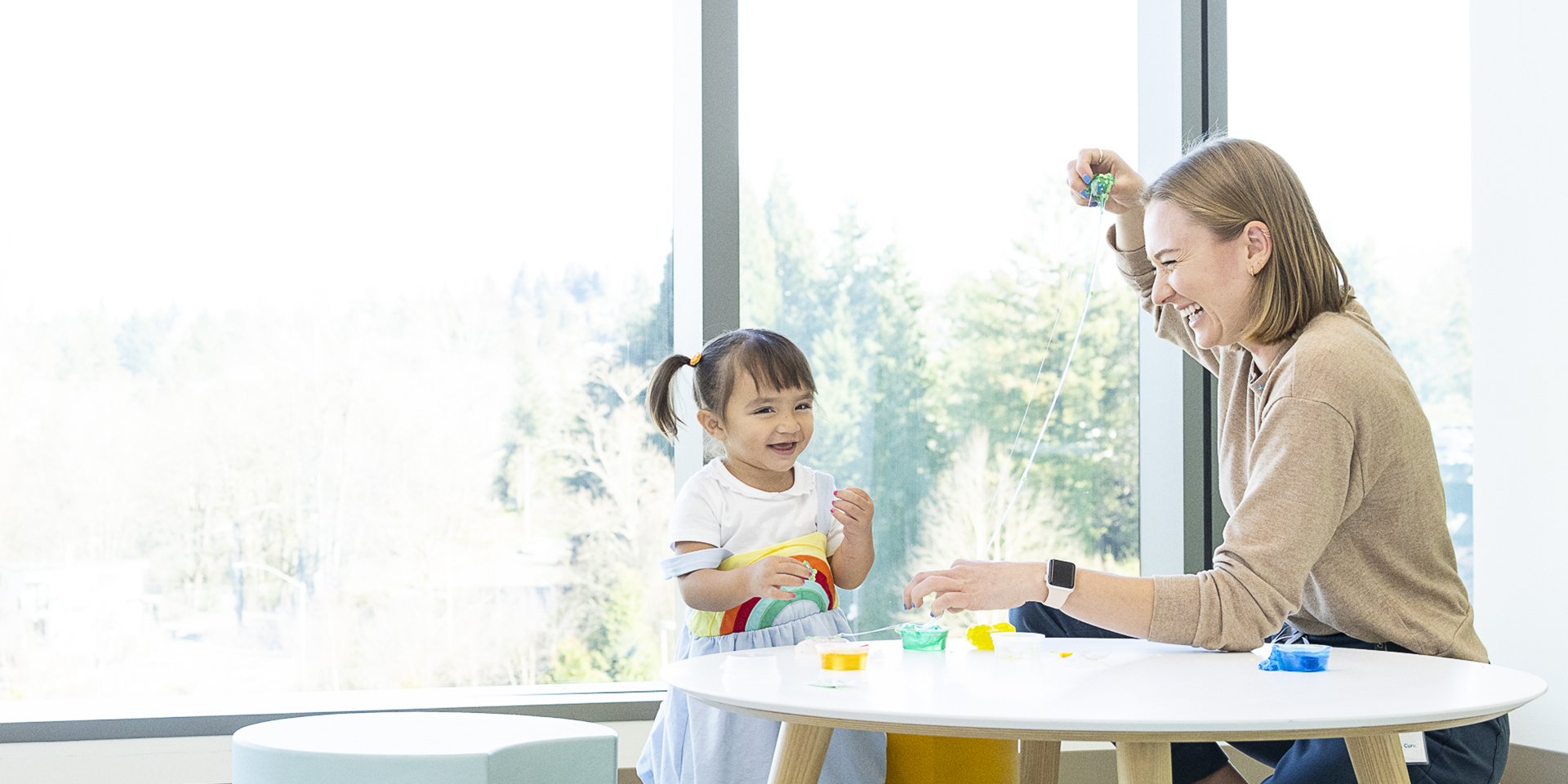 A little girl and provider playing at a children's table