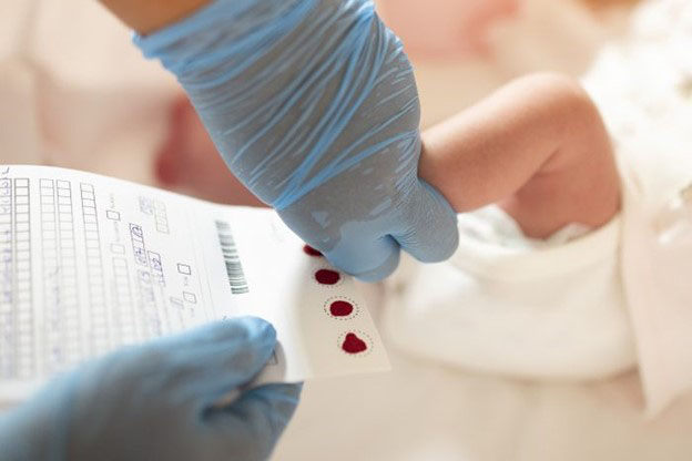 A medical professional take blood samples from a baby's foot